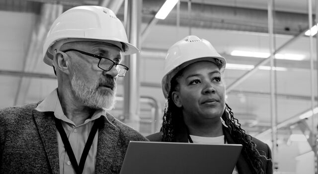 SINGLE-IMAGE_male-and-female-with-hard-hats-holding-laptop-no-squares_mar24