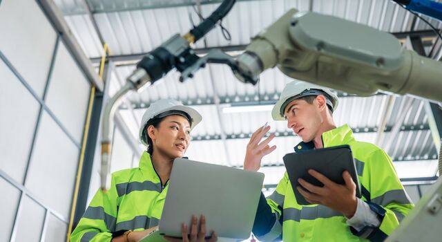 COLOUR-IMAGE_two-workers-wearing-hi-vis-coats-holding-devices_apr26