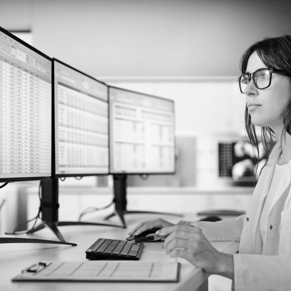 SINGLE-IMAGE_woman-at-computer-triple-monitors_aug25