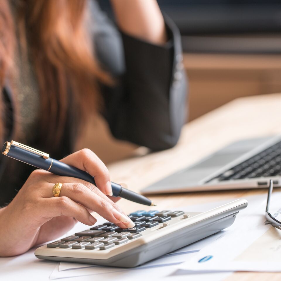 COLOUR-IMAGE_woman-holding-pen-with-calculator_feb26