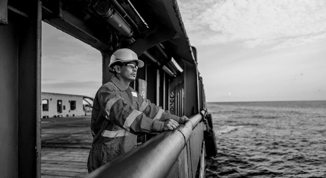 SINGLE-IMAGE_worker-on-boat-looking-to-sea-black-and-white_jul24