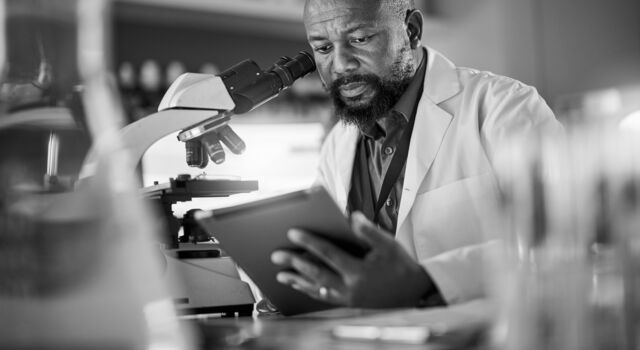 SINGLE-IMAGE_black-man-pharmacist-with-microscope_aug24